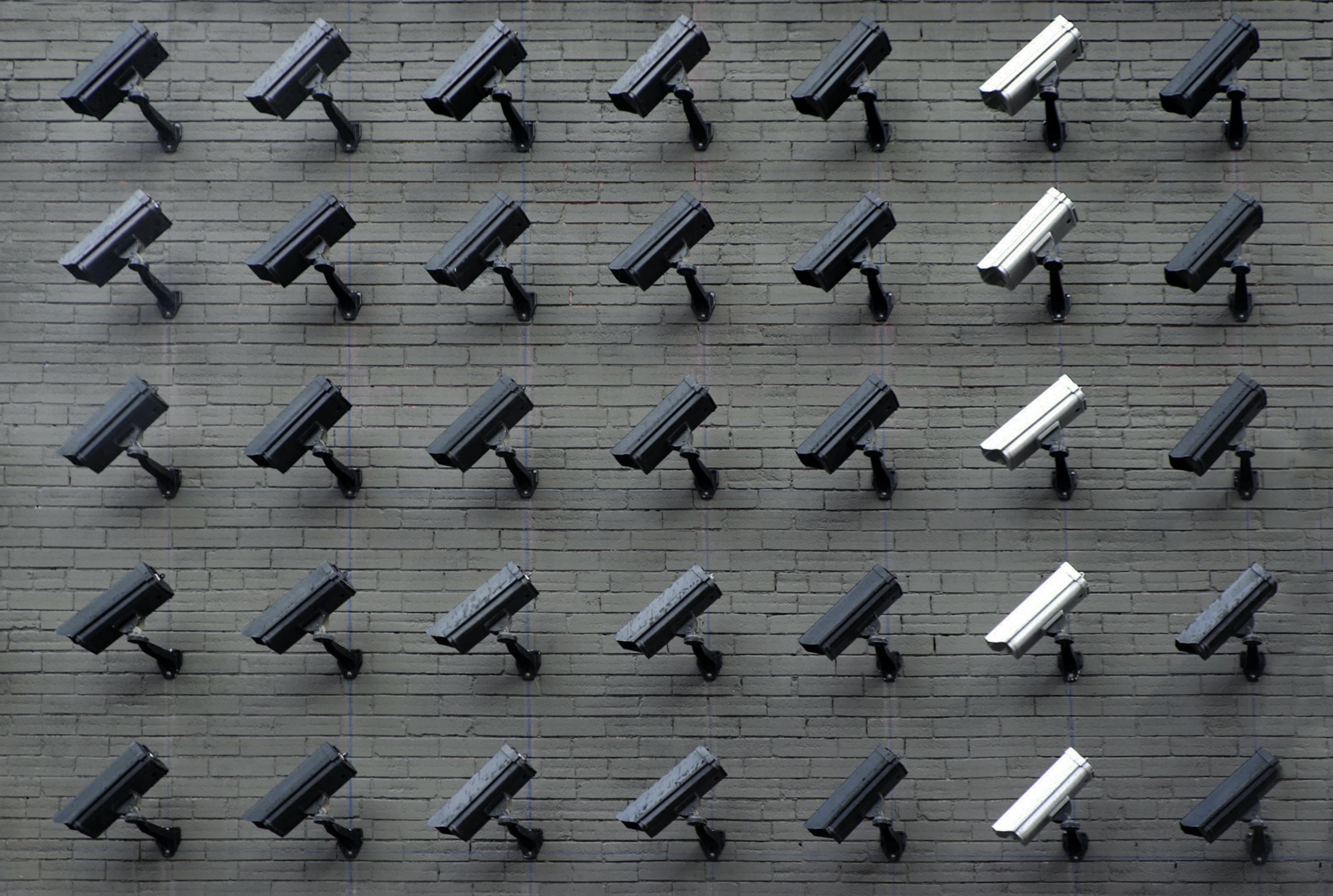Pared llena de cámaras de seguridad. Foto de Lianhao Qu en Unsplash